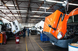 A row of semi trucks getting serviced in the shop at Delta Truck Center.